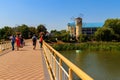 Unknown people walking on pedestrian bridge across Khorol river in wellness resort Myrhorod