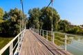 Unknown people walking on pedestrian bridge across Khorol river in wellness resort Myrhorod