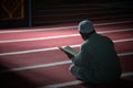An unknown person is reading the Koran with solemnity in a mosque