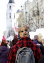 Unknown person in traditional lithuanian carnival mask walking in a street market on February 7, 2016 in Vilnius, Lithuania
