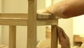 Professional carpenter sanding wooden chair with sandpaper to make the surface smooth