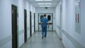 Surgeon going operation room back view. Doctor walking on hospital corridor Royalty Free Stock Photo