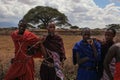 Unknown village near Amboselli park, Kenya - April 02, 2015: Unknown four Maasai warriors in traditional bright colored robes, ph
