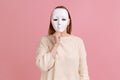 Unknown woman covering her face with white mask, hiding her real personality, anonymity.