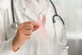 Unknown woman doctor holding pink ribbon in hospital for support people life and illness. October Breast Cancer Awareness month. Royalty Free Stock Photo