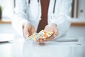 Unknown woman-doctor offering pack of different tablet blisters, close-up. Medicine concept