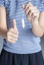 Unknown woman holds tampon and shows thumb