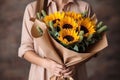 Unknown woman holds a wonderful bouquet of sunflowers in her hands. Mother& x27;s day, women& x27;s day and birthday