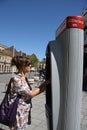 Unknown woman at the ticket machine for municipal bikes