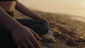 Woman body sitting lotus pose on sand beach close up. Slim girl meditating. Royalty Free Stock Photo