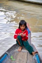 Unknown young girl sitting on a wooden boat