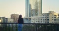 Unknown young lady walking on observation deck. Stylish tourist looking on town.