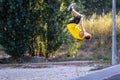 An unknown young man jumps and does somersaults.