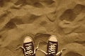 Unlaced pair of sneakers on beach, retro design, top view Royalty Free Stock Photo