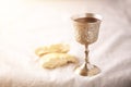 Unleavened bread, chalice of wine, silver kiddush wine cup on canva background. Communion still life. Christian communion concept