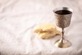 Unleavened bread, chalice of wine, silver kiddush wine cup on canva background. Communion still life. Christian communion concept