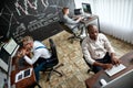 An unlimited way of learning. High-angle view of three traders sitting by desks in front of computer monitors while