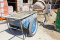 Wheelbarrow with mortar and empty cement mixer machine were placed on construction site Royalty Free Stock Photo