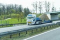 An unloaded truck equipped for transporting large cargo is driving along the highway.