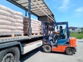 Unloading bags of cement from a truck with a forklift