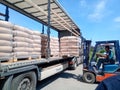 Unloading bags of cement from a truck with a forklift