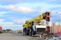 Unloading of cargo and building materials by mobile truck crane at the construction site.