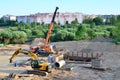 Unloading of cargo and building materials by mobile truck crane at the construction site.