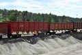 Unloading bulk cargo from railway wagons on of high railway platform. Royalty Free Stock Photo