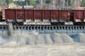 Unloading of crushed stone a railway car of a dump truck, closeup.