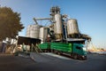 Unloading grain truck at elevator on elevating hydraulic platform unloader. Grain crops transshipment at big sea Royalty Free Stock Photo