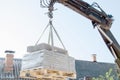 Unloading paving slabs from a truck. Men unload paving slabs using a manipulator. Workers unload building materials from Royalty Free Stock Photo
