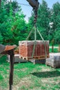 Unloading paving slabs from a truck. Men unload paving slabs using a manipulator. Workers unload building materials from Royalty Free Stock Photo