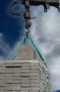 Unloading paving slabs from a truck. Men unload paving slabs using a manipulator. Workers unload building materials from Royalty Free Stock Photo