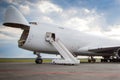 Unloading widebody cargo aircraft at the airport apron. Freight airplane bow compartment opened. Boarding stairs at the plane Royalty Free Stock Photo