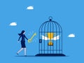 Unlock achievements. Businesswoman uses a key to release a trophy in a birdcage. business concept