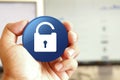 Unlock icon blue round button holding by hand infront of workspace background Royalty Free Stock Photo