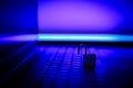 Unlocked padlock on the laptop keyboard, with purple lighting. Royalty Free Stock Photo
