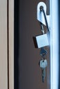 Unlocked silver padlock hanging on the white iron door. Royalty Free Stock Photo