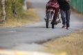 Unlucky man push forward dead motorcycle