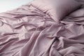 Unmade bed with purple satin sheets Royalty Free Stock Photo