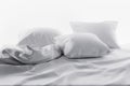 Unmade bed with soft clean white linen and pillows