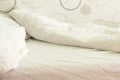 Unmade bed with white rumpled linen, close-up