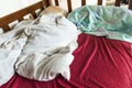 Unmade child bed with crumpled red and white bed linens and pill Royalty Free Stock Photo