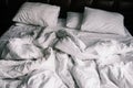 Unmade empty bed with white linens. Sheets and pillows in the apartment or hotel after a night`s sleep. Dirty and crumpled blanke Royalty Free Stock Photo