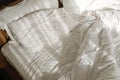 Unmade white bed with white bed sheet and pillow in the bedroom