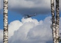 An unmarked gray combat helicopter against the background of clouds in the summer sky Royalty Free Stock Photo