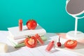 Unmarked lipsticks arranged on a table with fresh tomatoes and props against a turquoise background-perfect for cosmetic ads. The