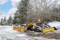 Unmarked snow plow vehicles sit empty in a parking lot after a winter storm in the mountains of North Idaho, USA