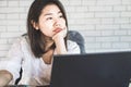 Unmotivated Asian female worker sitting at desk bored to work