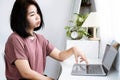 Asian Woman Feeling Bored and Lacking Inspiration to Start Working, Sitting in Front of Computer with No Ideas Royalty Free Stock Photo